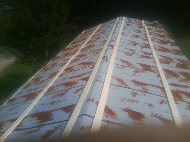 Rusted metal roof panels with new wood purlins before replacement — Storm Damage Roof Repair in Waskom by Roofing Brothers