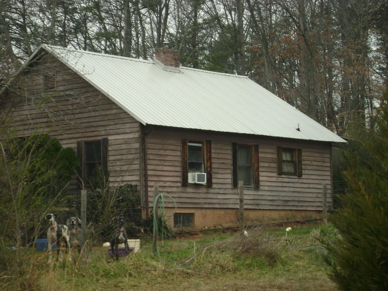 White metal roof on an old wood sided farmhouse, from a Metal Roof Installation job in Waskom